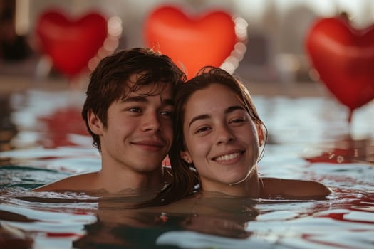 A couple in love is relaxing in a pool against a background of red balls in the form of hearts. Valentine's day.