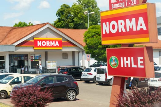 Grafenau, Germany - June 9, 2023: Cars parked outside the Norma supermarket with a clear sky, showcasing the stores exterior and signage during business hours.