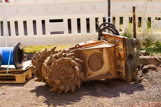 A mounted road mill lies on a street repair site in the city.