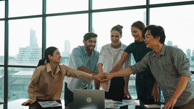 Group of multicultural businesspeople putting hands together at modern office. Happy cooperative business team working together. Represented unity, working together, teamwork, work place. Tracery