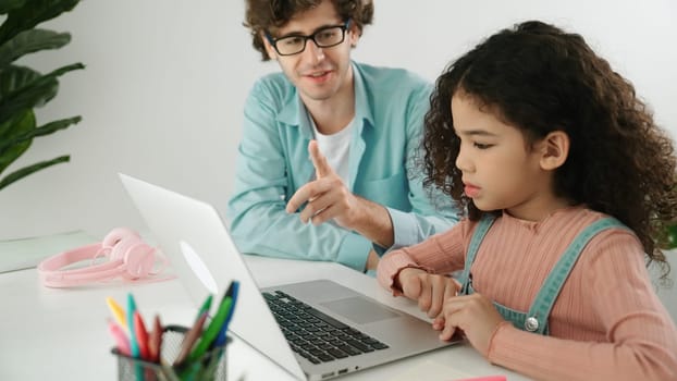 Caucasian father help student doing homework about engineering code while happy school girl. Dad take care cute child while teaching about generative AI at table with laptop and headphone. Pedagogy.
