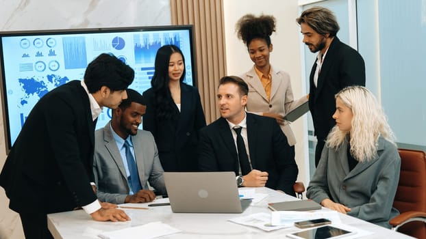 Analyst team utilizing BI Fintech to analyze financial data at table in ornamented meeting room. Businesspeople analyzing BI dashboard power for business insight and strategic marketing planning.