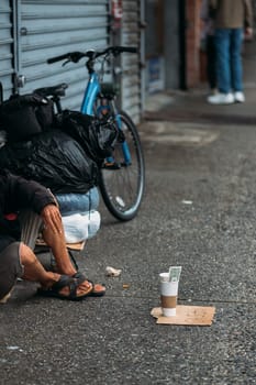 A candid snapshot of urban struggle with a homeless person amidst city life.