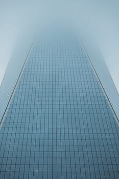 The sleek lines of a skyscraper rise with a blue gradient backdrop.