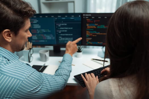 Team skilled developers program coding discussing creative website planning software project on two screen monitor's full stack data analyzing design at office with back side view concept. Postulate.