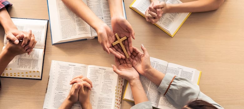 Close-up women prayer deliver holy bible book and holy cross to believer group. Spreading religion symbol. Concept of hope, religion, christianity and god blessing. Warm background. Burgeoning.