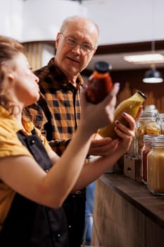 Father and daughter shopping in zero waste store looking for farm grown bulk products. Family members purchasing pantry staples from local neighborhood shop fighting against consumerism culture