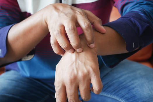 man suffering from itching skin, close up