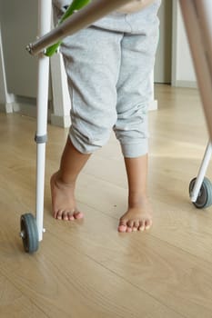 child with walking frame and knee orthosis indoor .