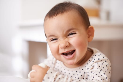 Baby, toddler portrait and laugh in home, childhood and smile for enjoyment or fun in bedroom. Girl, kid and happy for child development and relax by bed, satisfaction and face for humor or silly.