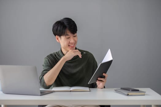 Portrait of a handsome young office worker intently studying how to do a presentation project on a laptop in his office..