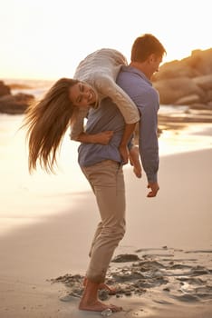 Beach, man and woman with playful love together for romantic date, travel or holiday on island. Ocean, vacation and couple smile in sand for tropical adventure for honeymoon, anniversary and sunset.