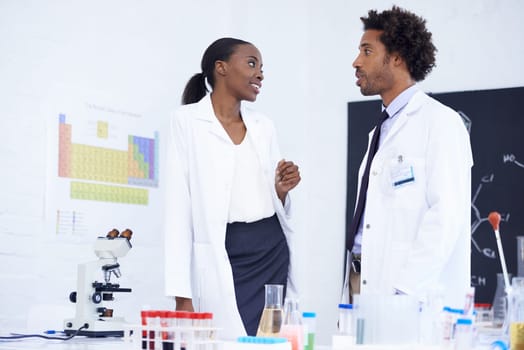 Scientist, man and woman with discussion in laboratory for chemical research, medical review and study feedback. Science, african expert and collaboration with communication and chemistry planning.