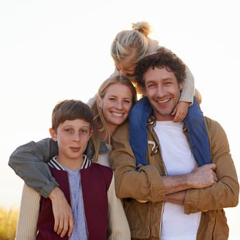 Family, portrait and smile with countryside, walk and sunrise for morning exercise and bond. Parents, children and field for health, wellness and outdoor adventure at sunset for holiday or vacation