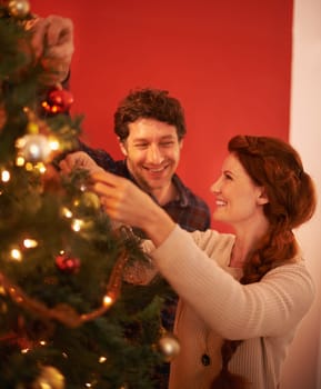 Couple, tree and christmas with smile, decoration and celebration for holiday spirit. Man, woman and love with happy marriage, relationship and romance with ornament for vacation break and care.