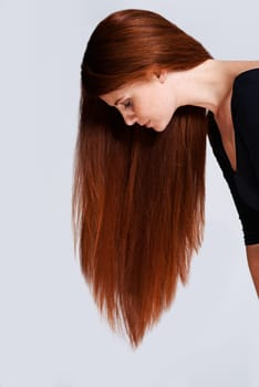 Woman, red hair and beauty with cosmetic care, keratin treatment for shine with healthy growth on white background. Redhead, ginger and haircare for wellness, volume and texture with length in studio.