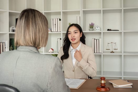 A young lawyer and businesswoman are discussing legal advice on signing a business contract. Insurance or financial contract signing.