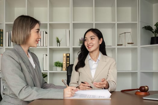 Lawyer and businesswomen discussing and introducing Providing legal advice regarding signing insurance contracts or financial contracts.