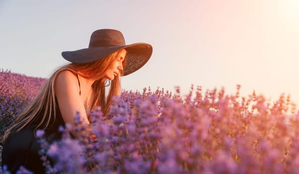 Close up portrait of young beautiful woman in a white dress and a hat is walking in the lavender field and smelling lavender bouquet.