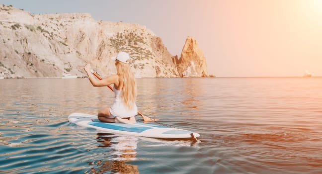 Close up shot of beautiful young caucasian woman with black hair and freckles looking at camera and smiling. Cute woman portrait in a pink bikini posing on a volcanic rock high above the sea