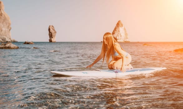 Close up shot of happy young caucasian woman looking at camera and smiling. Cute woman portrait in bikini posing on a volcanic rock high above the sea