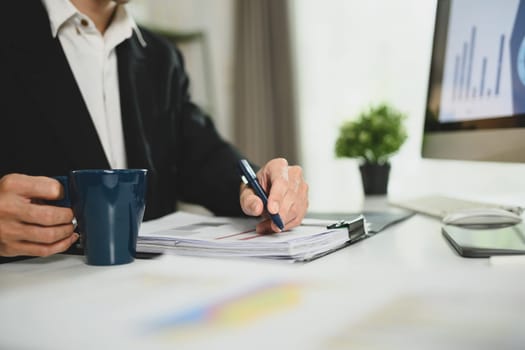 Cropped shot of businessman analyzing marketing data and statistics at workplace.