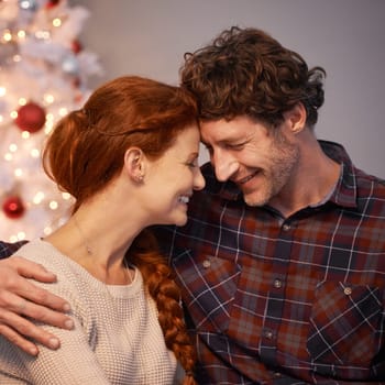 Christmas, tree and couple together with love for holiday in home, smile and happiness. Marriage, woman and man as husband and wife in house for celebration of festive, season and romance in vacation.