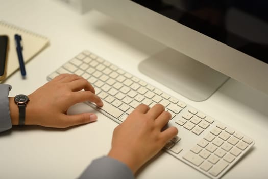 Closeup of woman typing on computer keyboard working on online project or chatting with client.