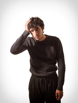 A man in a black sweater is holding his head, because of depression, sadness, despair, isolated on white background