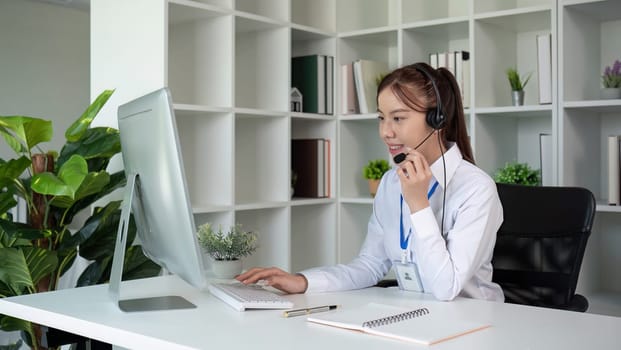 Call center agents wear headphones to talk to customers. Provide consultation via online channels on laptops.