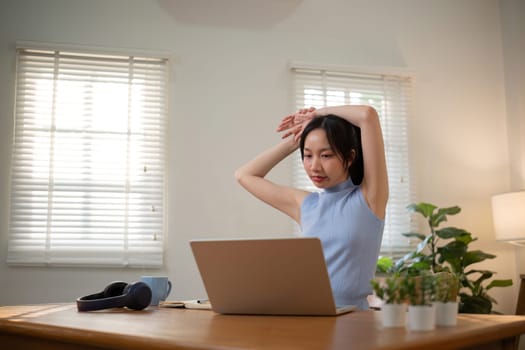 Asian college student who is bored Sitting in front of a laptop studying online through a video calling program on a laptop at home..