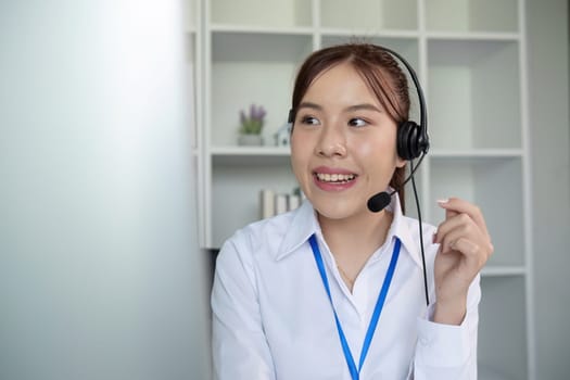 Call center agents wear headphones to talk to customers. Provide consultation via online channels on laptops.