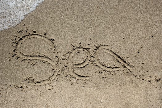 Word beach written on sand with wave coming - SEA
