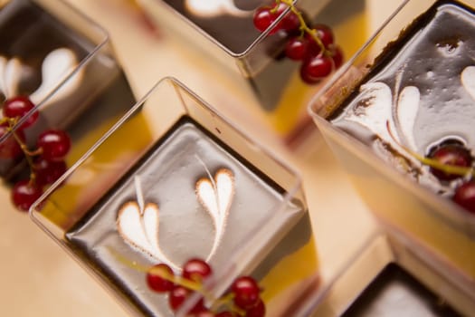 Layered dessert with fruits, nuts and cream cheese in glass jar, selective focus