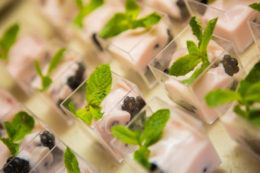 Layered dessert with fruits, nuts and cream cheese in glass jar, selective focus