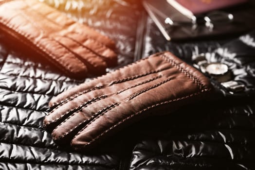 Pair of men's brown leather gloves and other men's accessories.