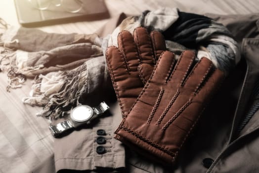 Pair of men's brown leather gloves and other men's accessories.