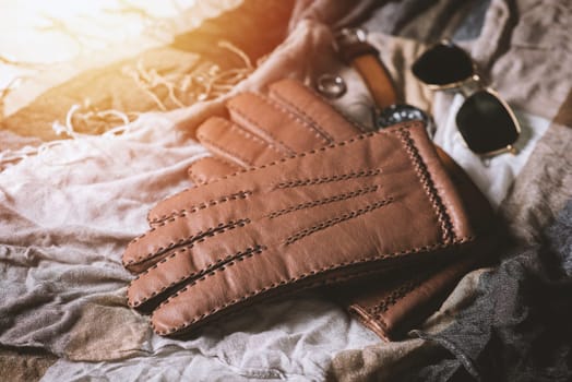 Pair of men's brown leather gloves and other men's accessories.