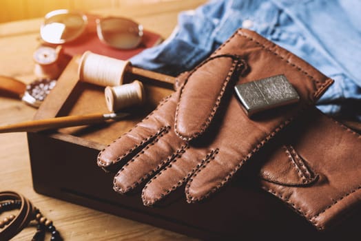 Pair of men's brown leather gloves and other men's accessories.