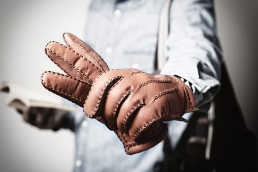 A man wearing the brown leather gloves in winter.