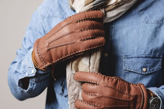 A man wearing the brown leather gloves in winter.