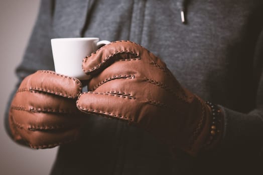 A man wearing the brown leather gloves in winter.