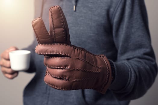 A man wearing the brown leather gloves in winter.