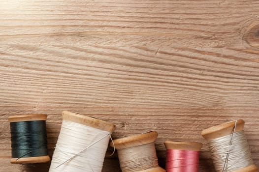 closeup thread for sewing and needlework on wooden background