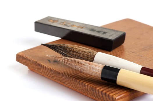 inkstone, inkstick and traditional writing brush isolated on white background