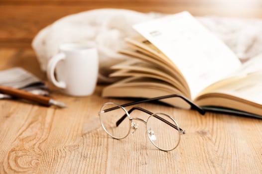 closeup round frame style of eyeglasses on wooden desk, shallow depth of field