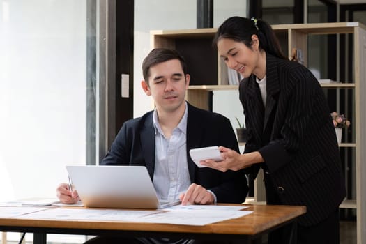 Two businessmen discussing project at the office room Businessman discusses project planning with colleagues in modern workplace while having discussion and advice on financial data report..