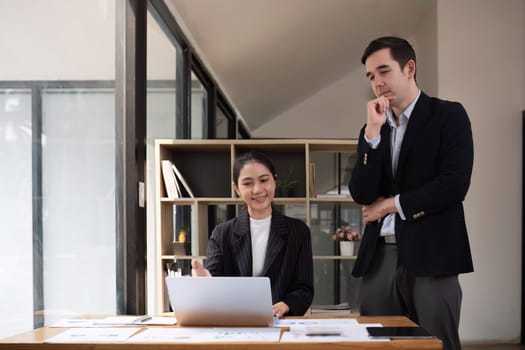 Two businessmen discussing project at the office room Businessman discusses project planning with colleagues in modern workplace while having discussion and advice on financial data report..