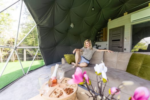 Transparent bubble tent at glamping, Lush forest around and interior. woman resting in glamping.