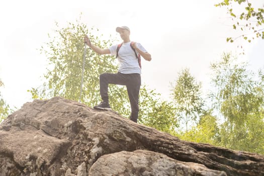 man hand holding hiking pole with green bokeh background and copy space. Summer activity for adventure person concept